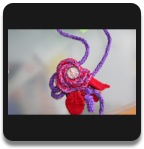 Kette gestrickt mit Blumenanh&auml;nger/Kronverschluss mit Cabochon-Motiv